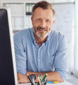 older online teacher smiling in front of desktop